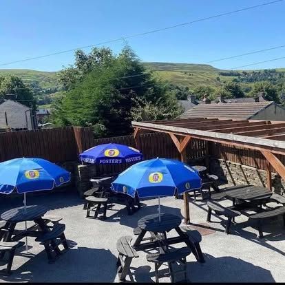 Outdoor pub area with blue parasols over picnic tables, Excellent beer garden, a real sun-trap with Rossendale Valley Views