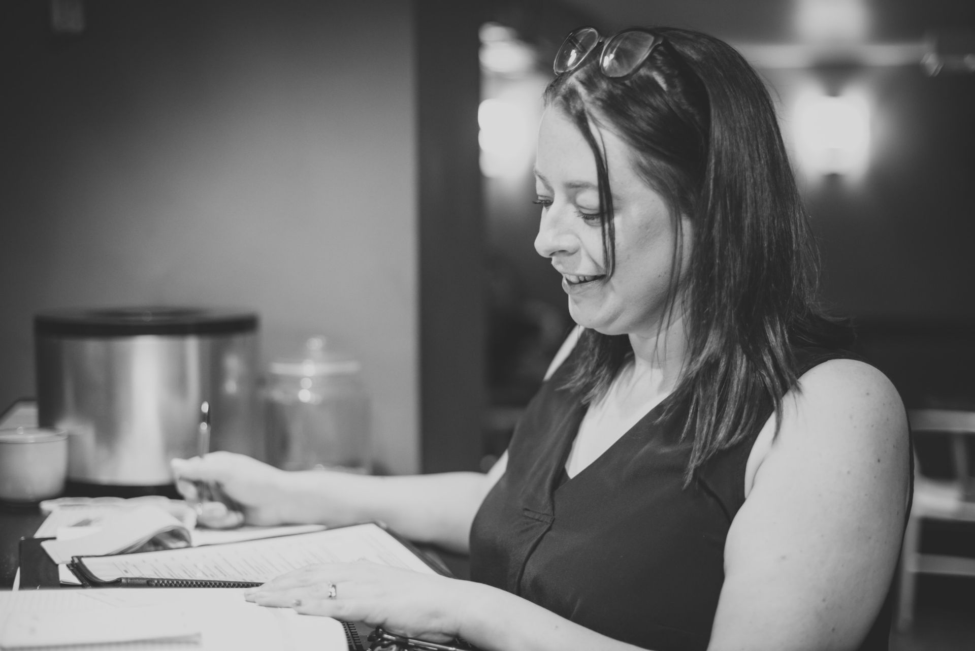 Woman smiling, writing on paper at counter with glasses on head. at the Boot & Shoe Waterfoot, Rossendale