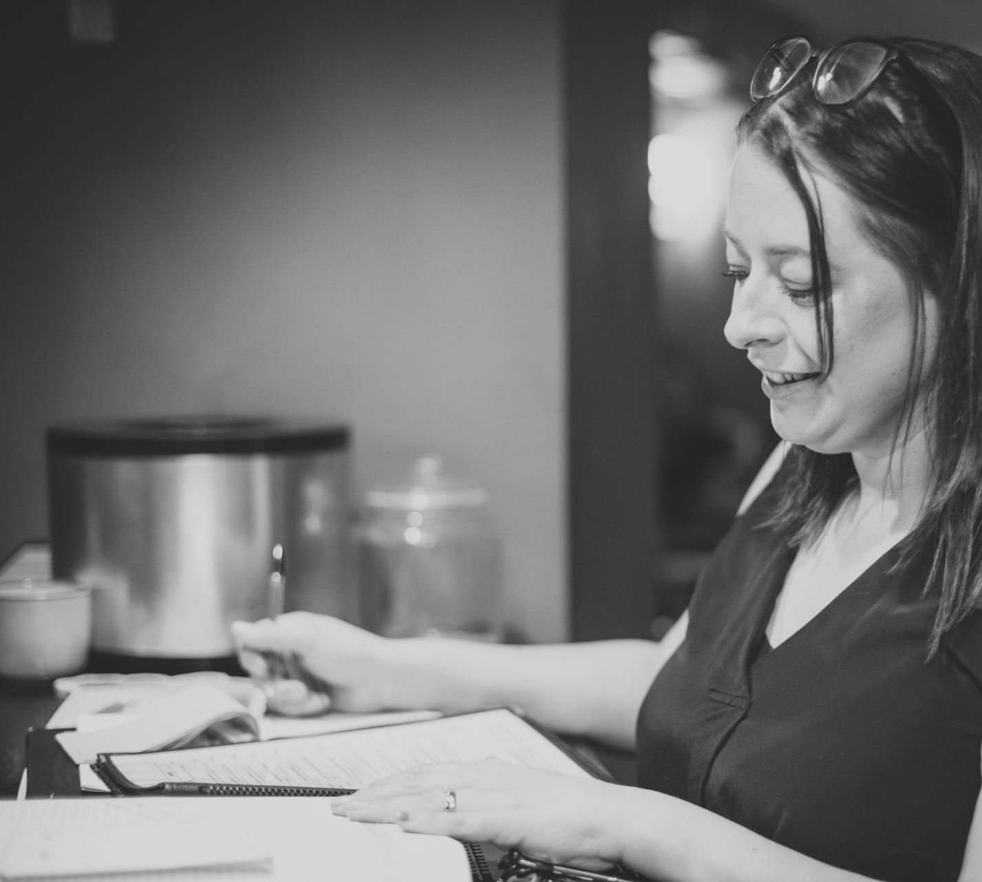 Woman reading a document, smiling. Glasses on her head, Book a table at the Boot & Shoe, Waterfoot, Rossendale