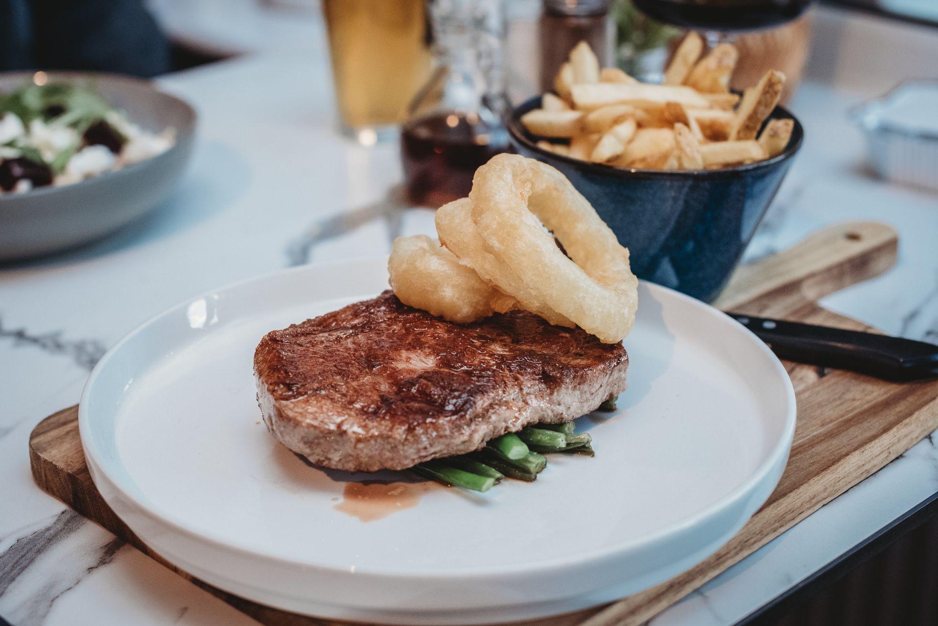 Steak with onion rings and asparagus, served with fries and a drink. Food at the Boot & Shoe, Waterfoot, Rossendale