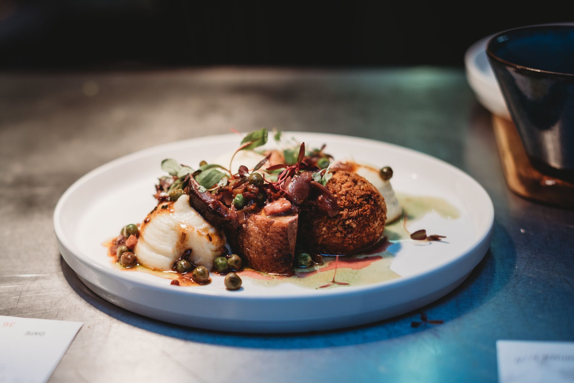 Gourmet food: seared scallops, fried croquette, and sauce with garnish. Food at the Boot & Shoe, Waterfoot, Rossendale