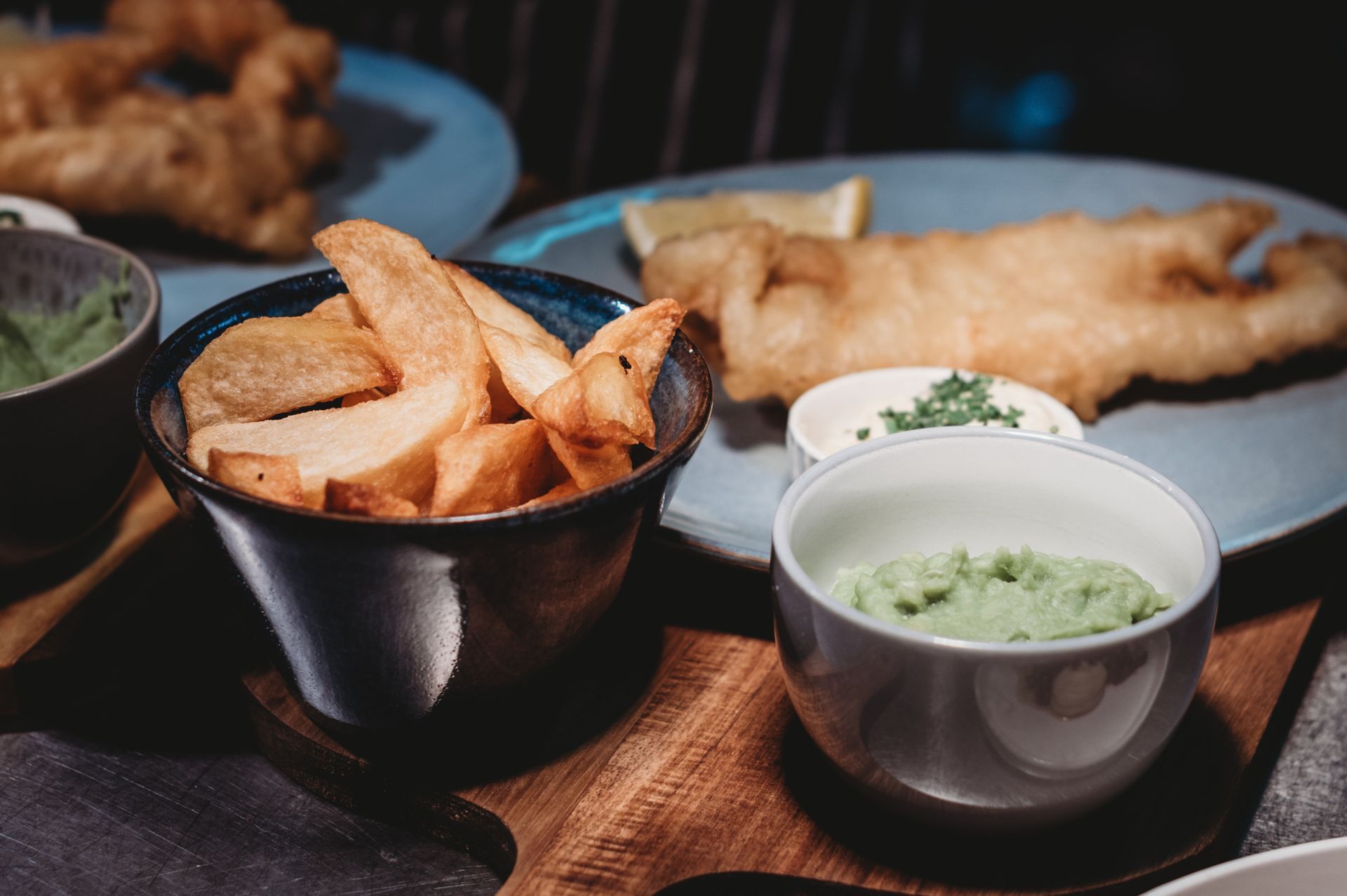 Fish and chips with dipping sauces on a wooden board. Chippy Friday at the Boot & Shoe, Waterfoot, Rossendale