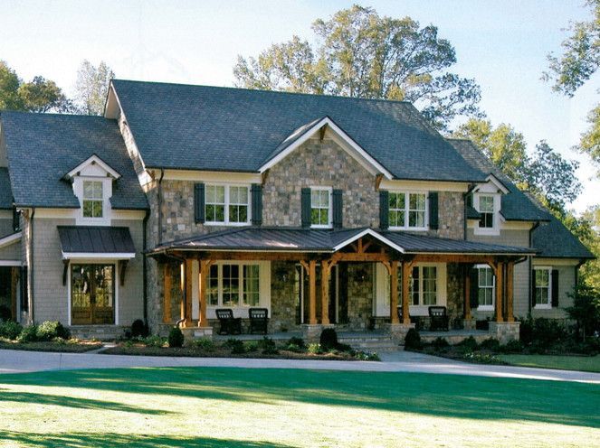 Two-story house with stone and gray siding, covered porch, and green lawn.