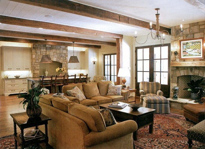 Rustic living room with stone accents, wood beams, and a cozy sofa.