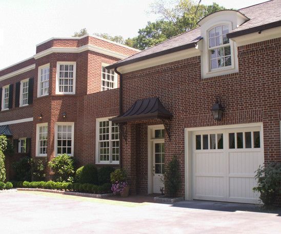 Brick house with white trim, garage door, and entrance.