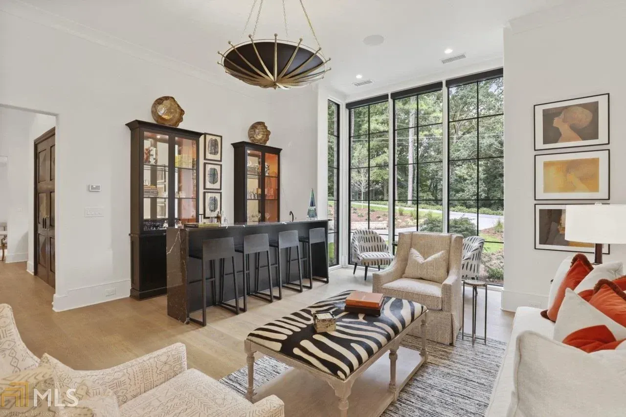 Elegant bar area with seating, large windows, and a zebra-print ottoman.