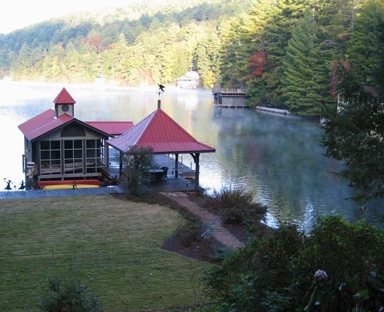 Lakeside gazebo with red roof and screen porch, in a misty lake setting.