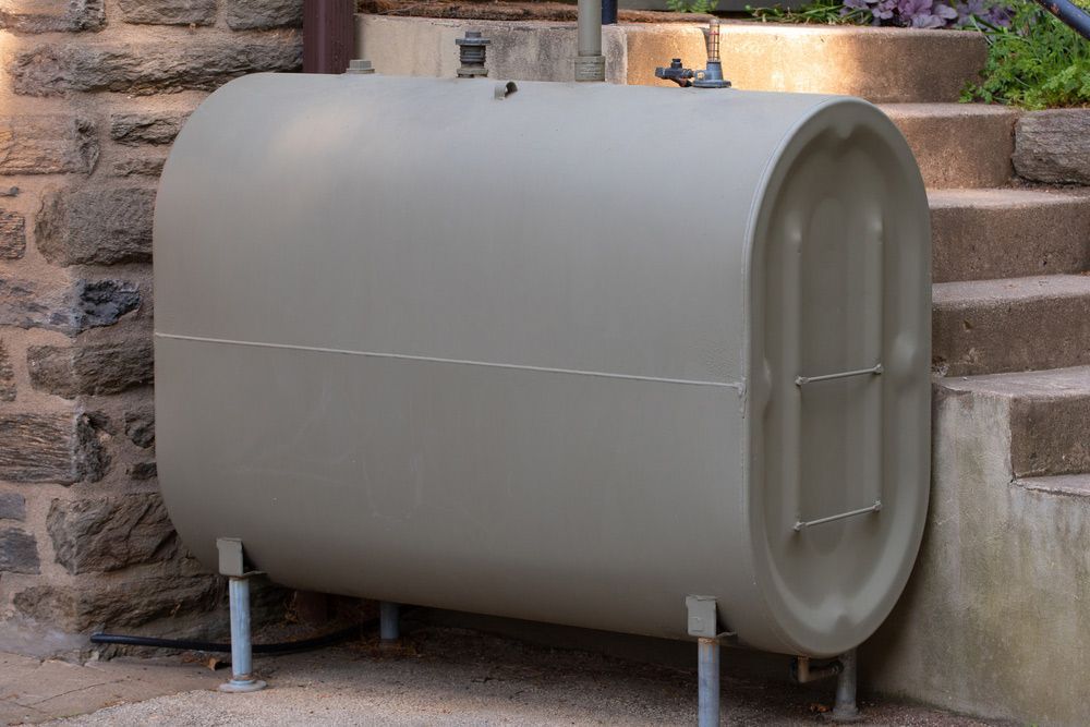 A Large Metal Tank is Sitting on the Side of a Stone Building Next to Stairs — Pootanky Murwillumbah, NSW