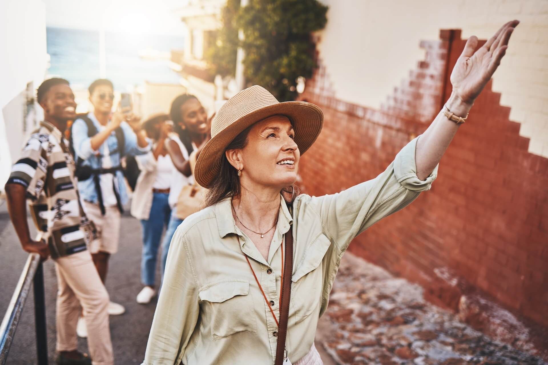 A woman in a hat is giving a tour to a group of people.