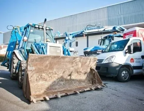 Un bulldozer è parcheggiato accanto a un furgone bianco
