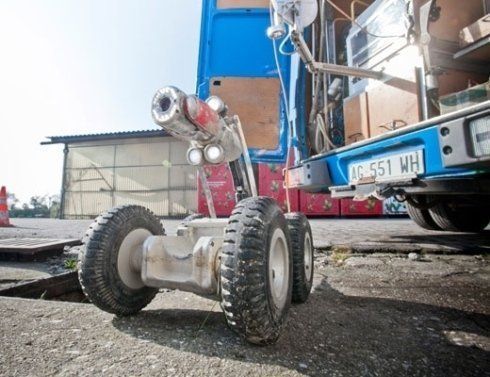 Un veicolo robotico è parcheggiato davanti a un camion blu
