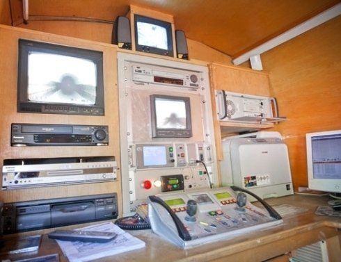 Una stanza con un sacco di elettronica e un telecomando