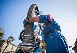 Un uomo in tuta blu sta lavorando su una macchina.