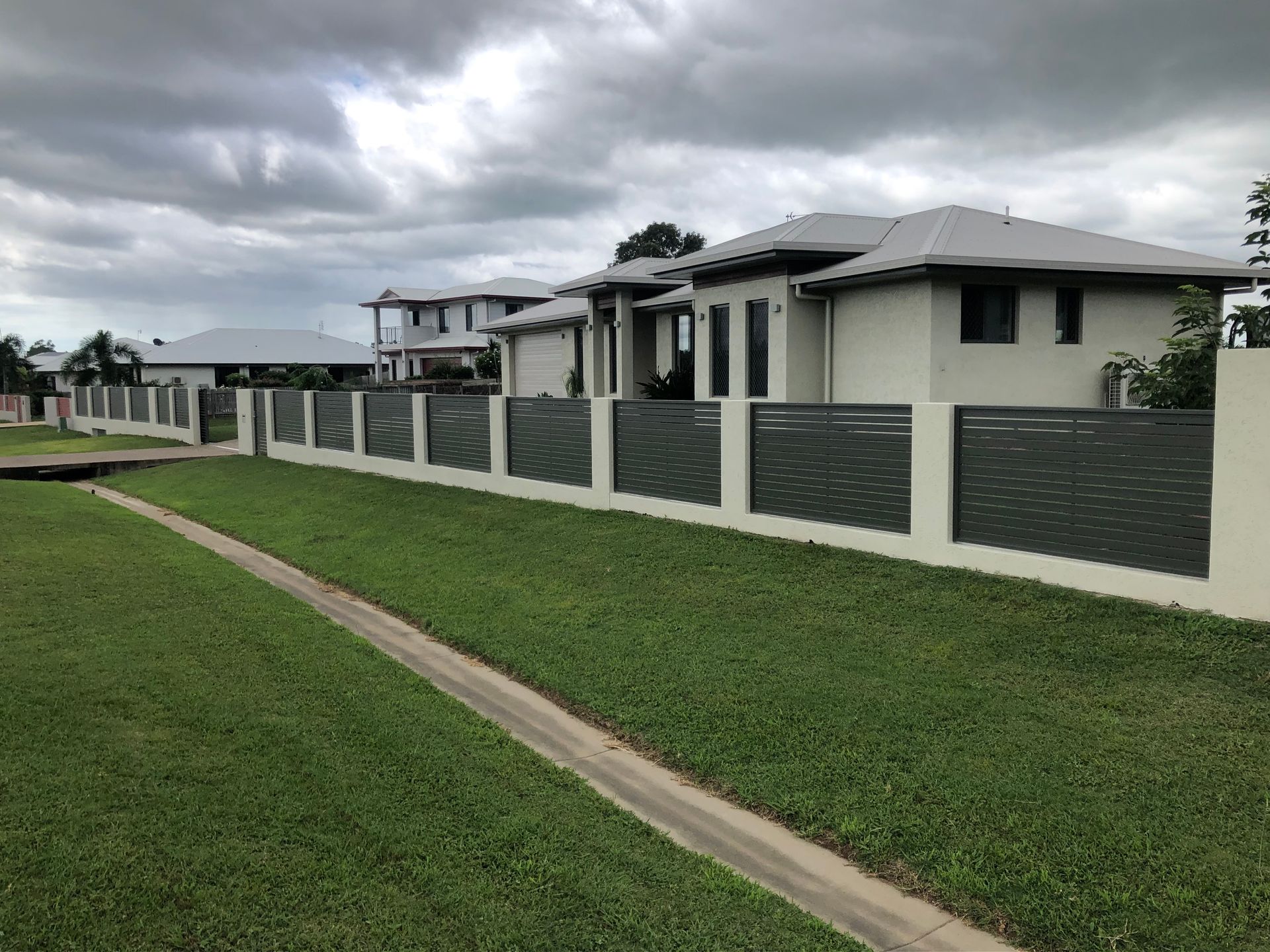 Residential Homes Behind a Grey and White Fence — Lifestyle Aluminium Lattice in Rasmussen, QLD