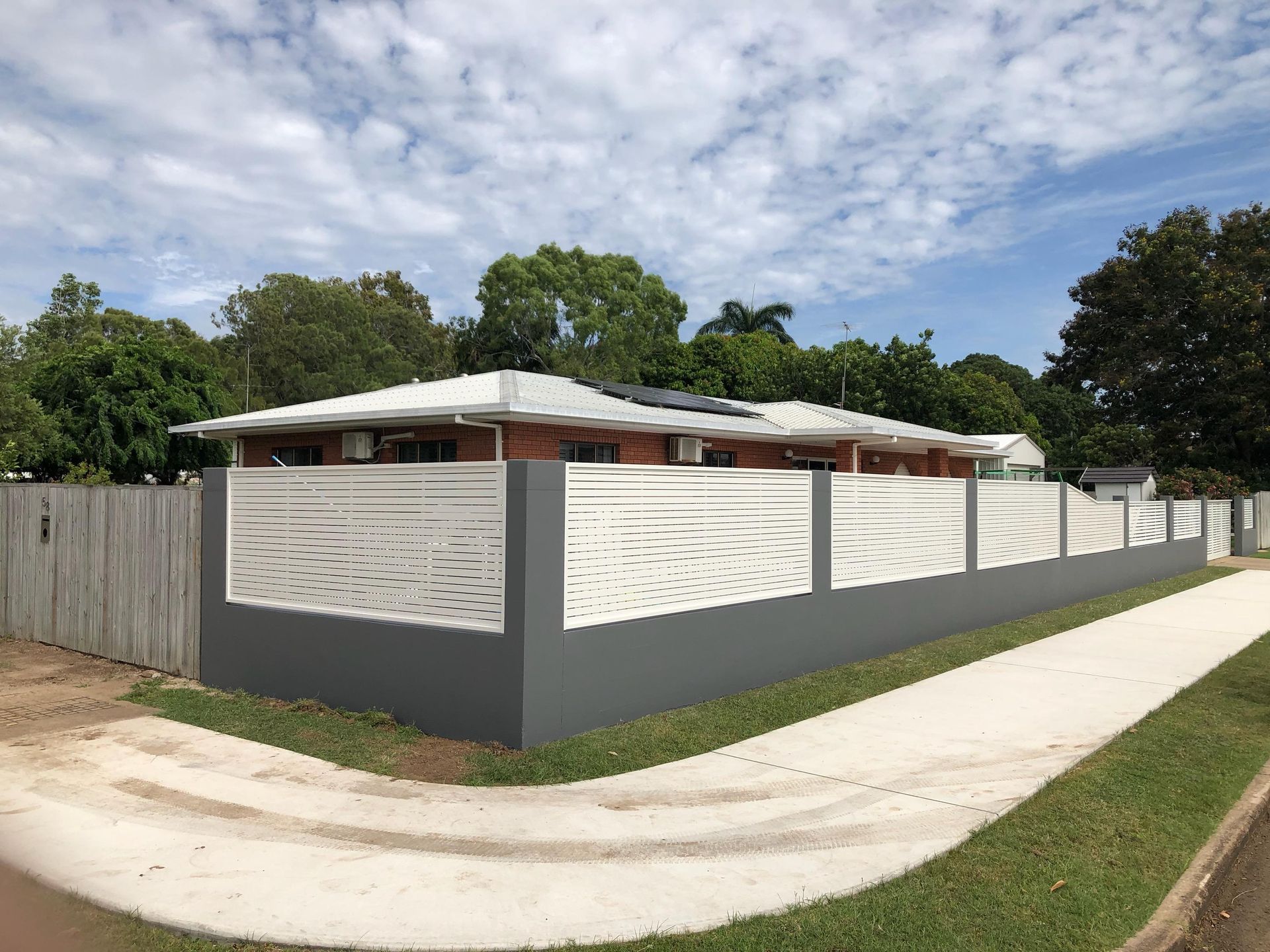 Gray and White Fence With Decorative Cutouts in Front of a Brick — Lifestyle Aluminium Lattice in West End, QLD