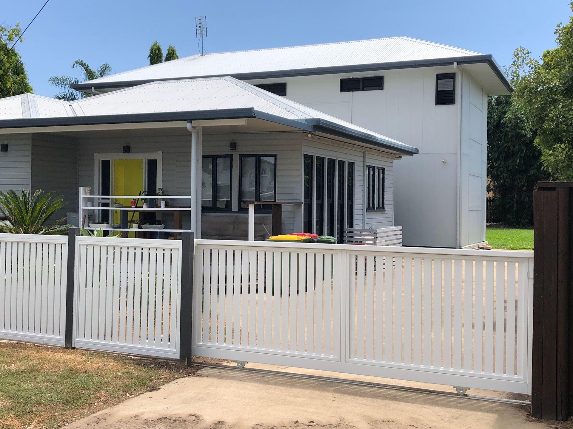 White Two-story House With a White Picket Fence and Yellow Front Door — Lifestyle Aluminium Lattice in West End, QLD