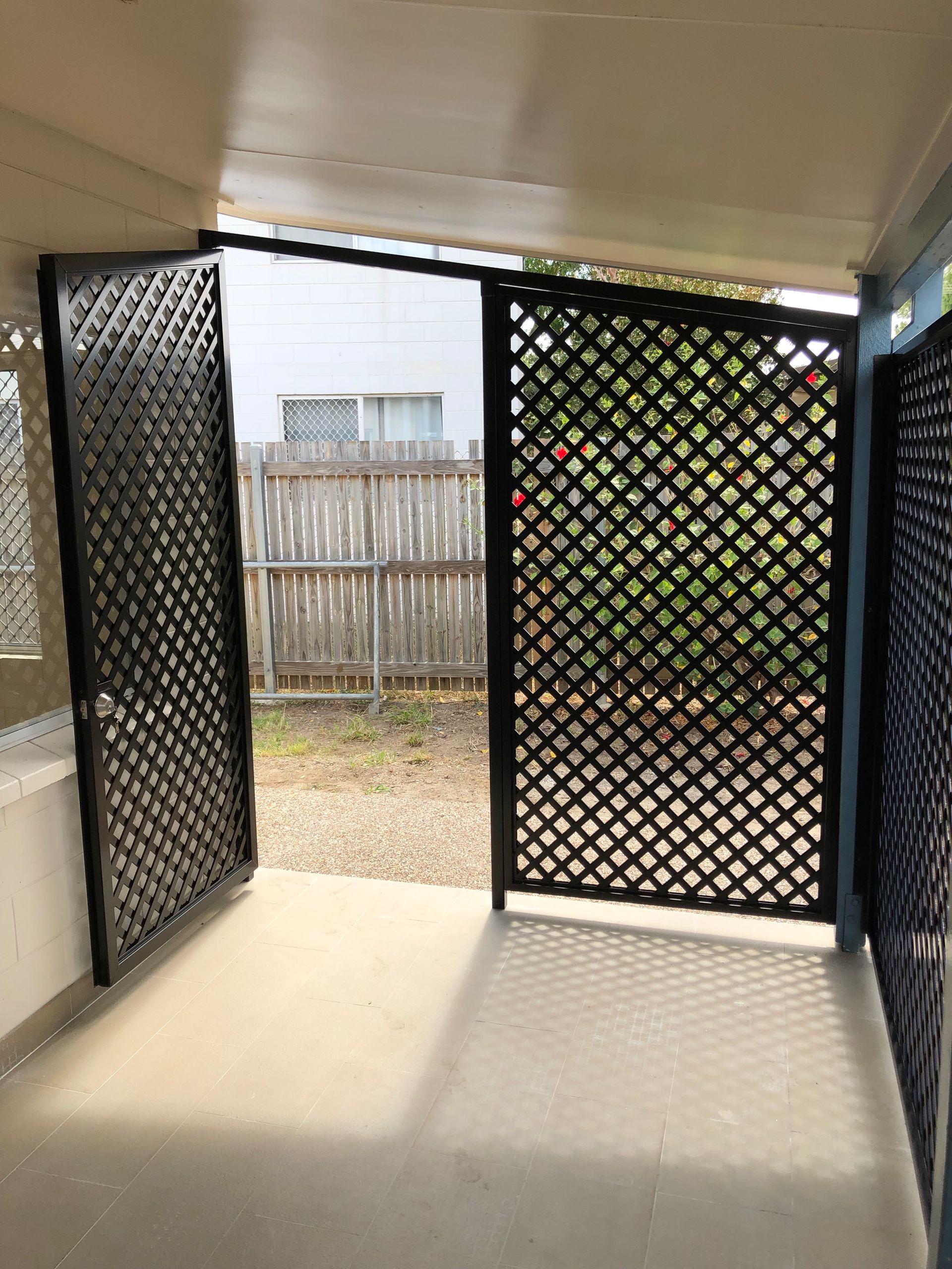 Black Latticed Doors Open Onto a Backyard — Lifestyle Aluminium Lattice in West End, QLD