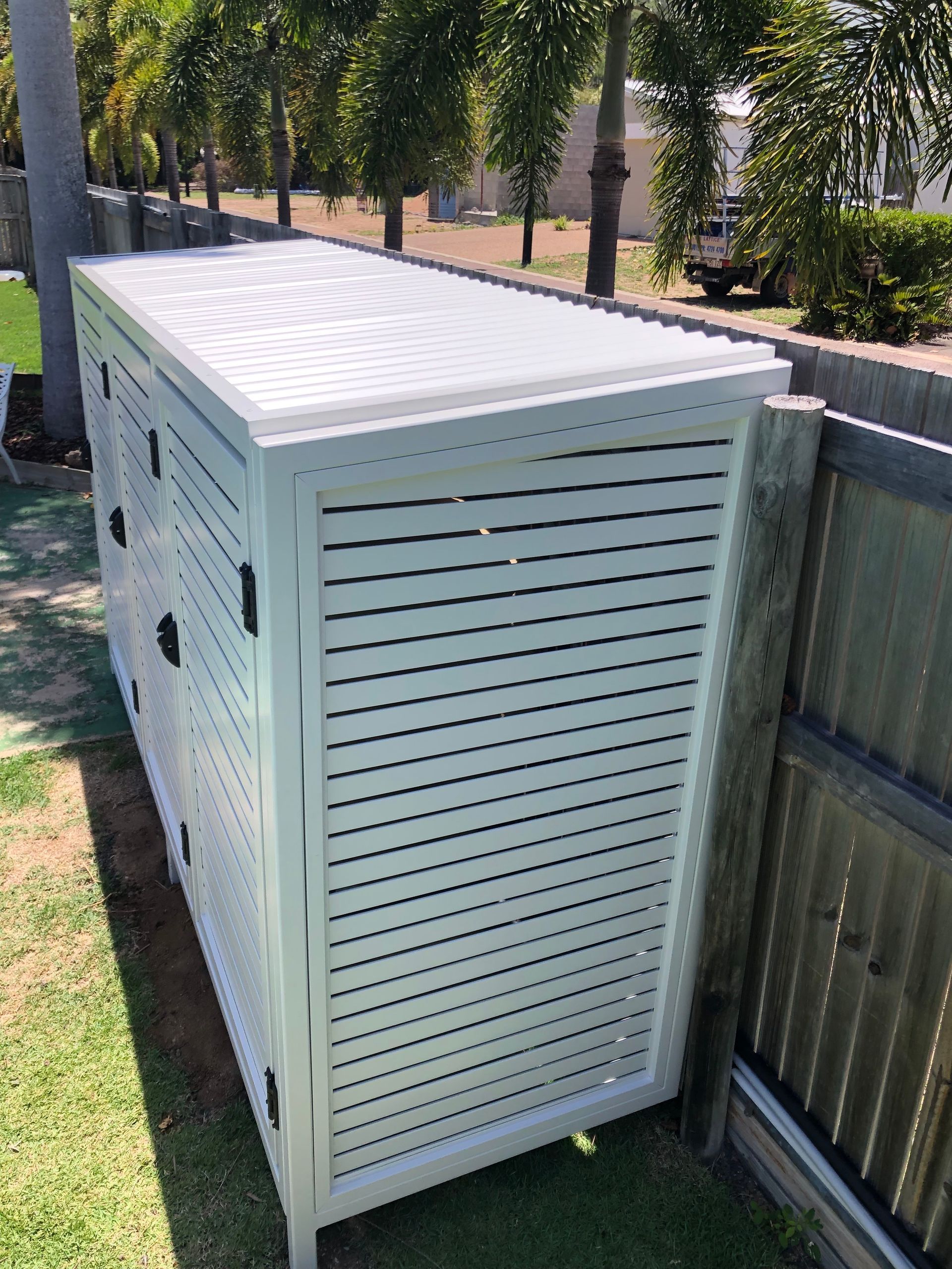 White Louvered Storage Shed Next to a Fence, in a Grassy Area — Lifestyle Aluminium Lattice in Mount Louisa, QLD