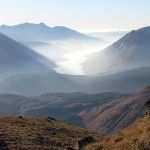 Mountains with a valley filled with fog, seen from an elevated perspective.