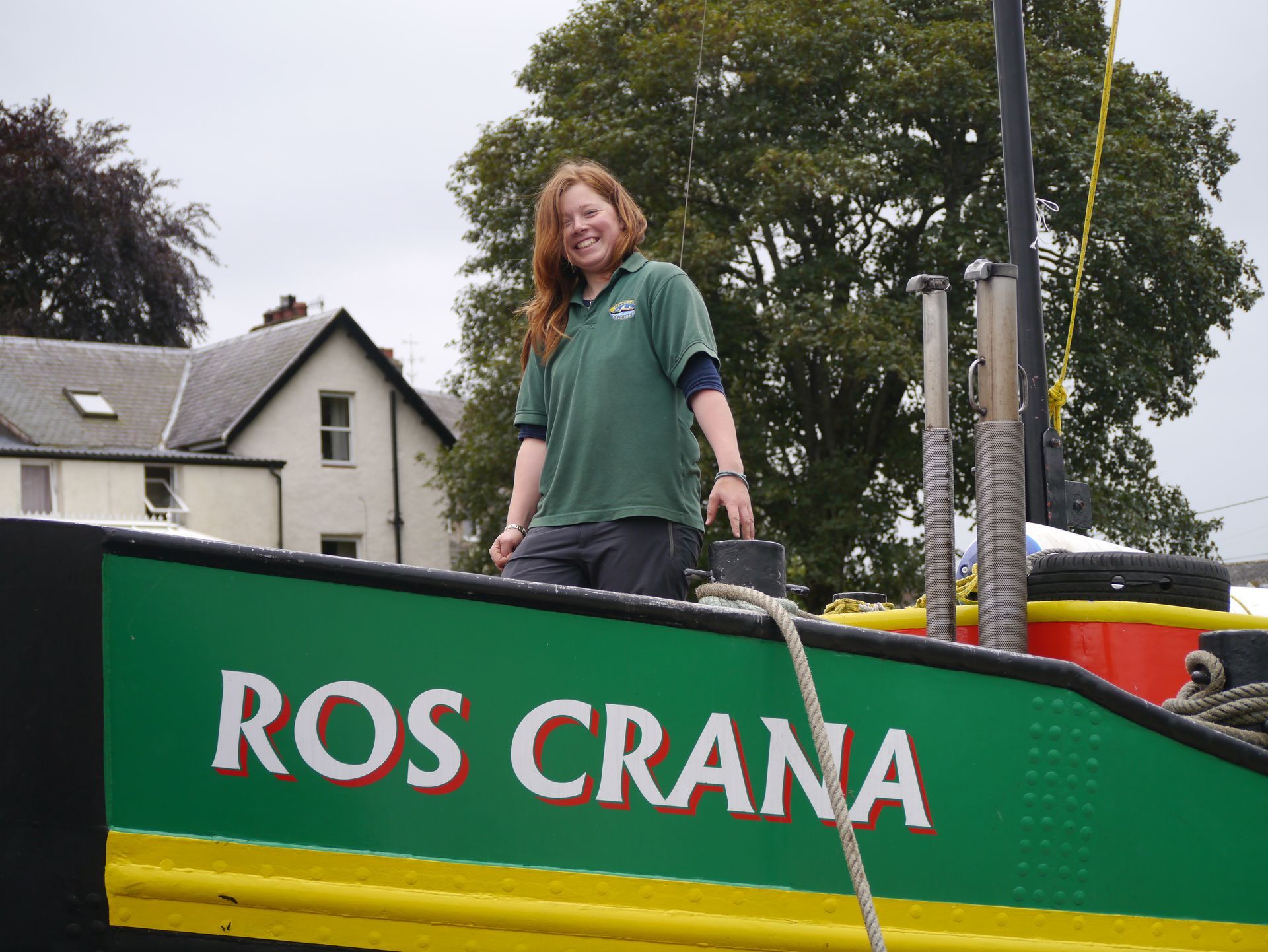 Woman smiles on a green and black boat, 