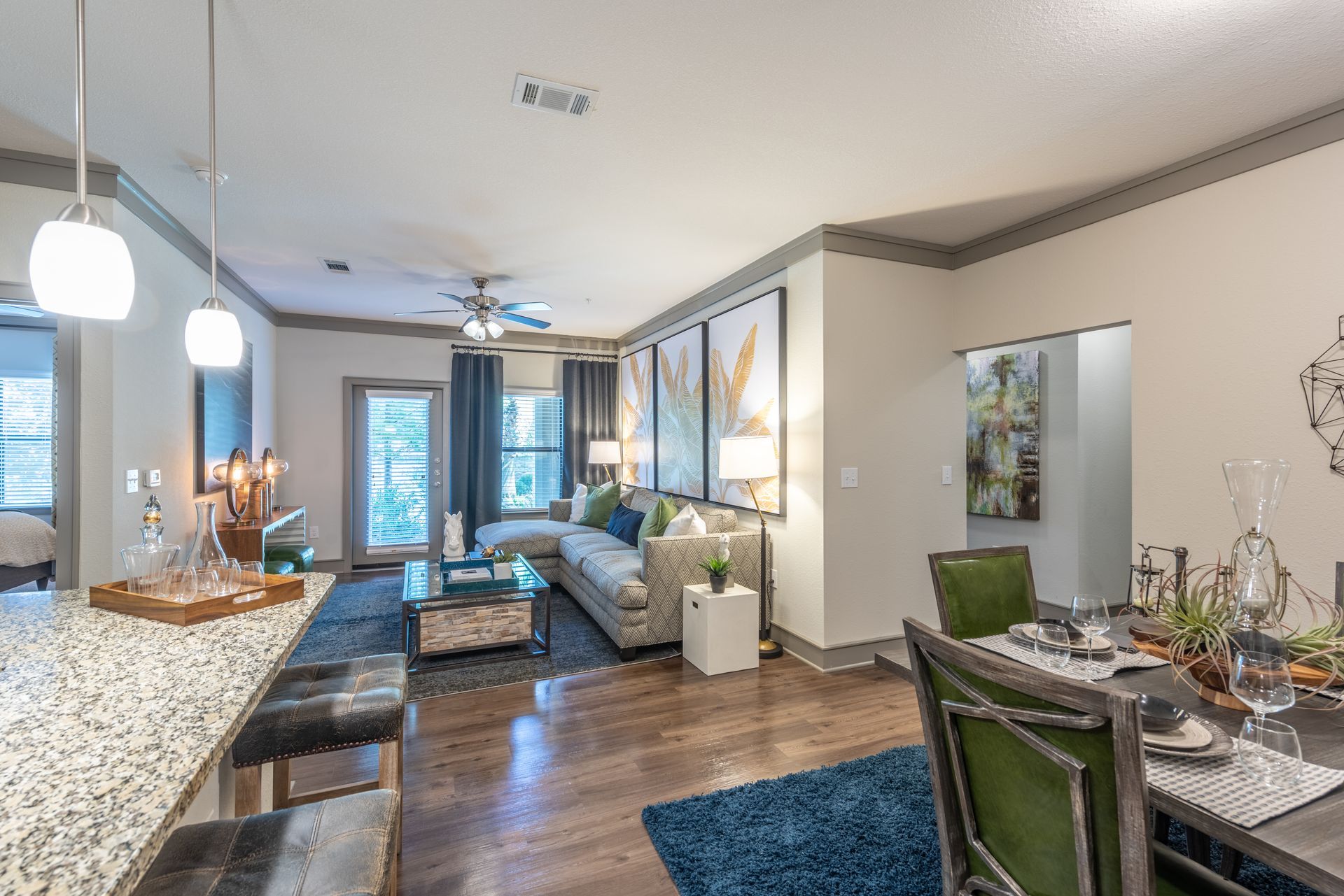 A living room with a couch, chairs, a table and a ceiling fan at Marquis Seven Lakes, offers apartments for rent in Katy, TX.