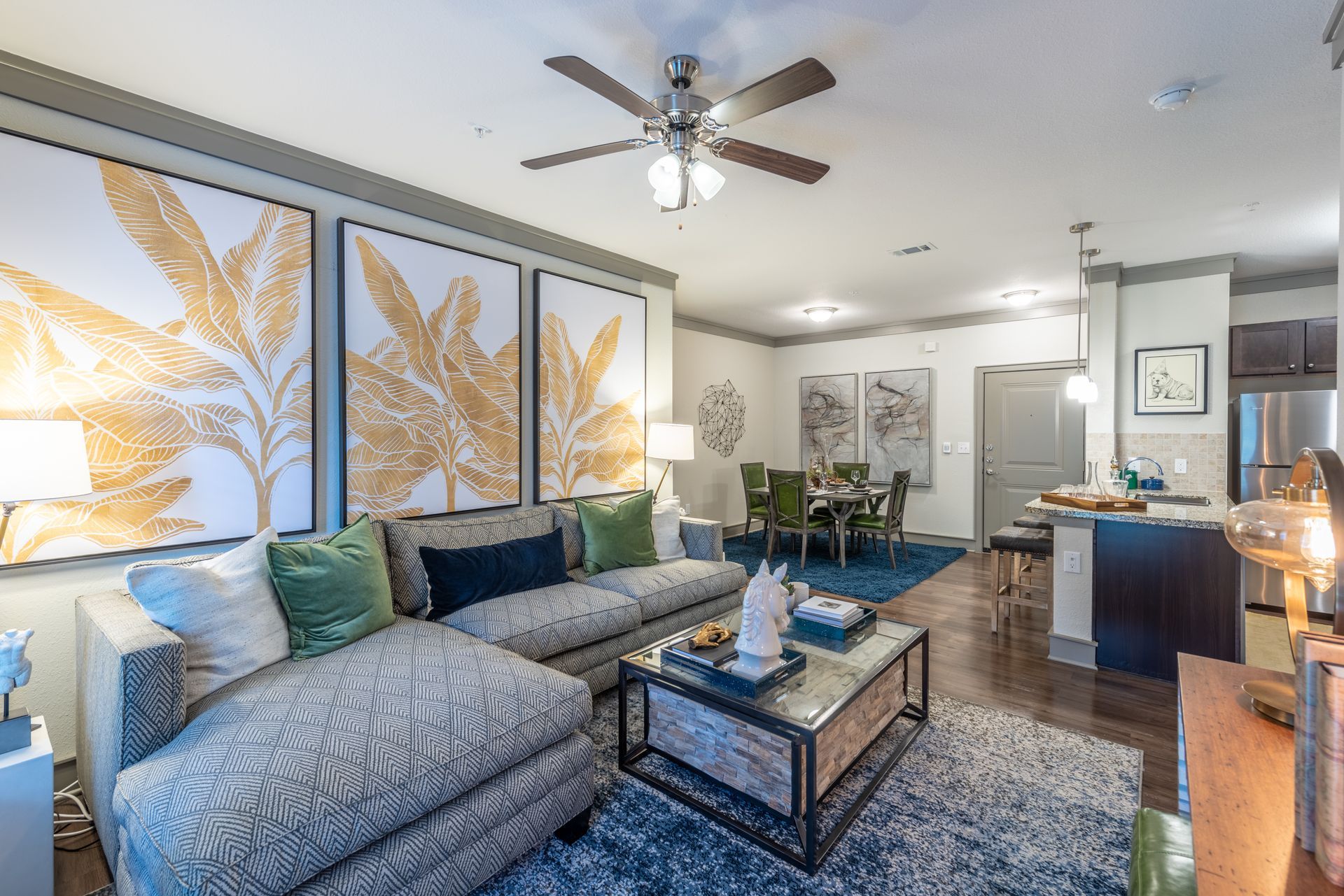 A living room with a couch, coffee table, and ceiling fan at Marquis Seven Lakes offers Cinco Ranch apartments for rent.