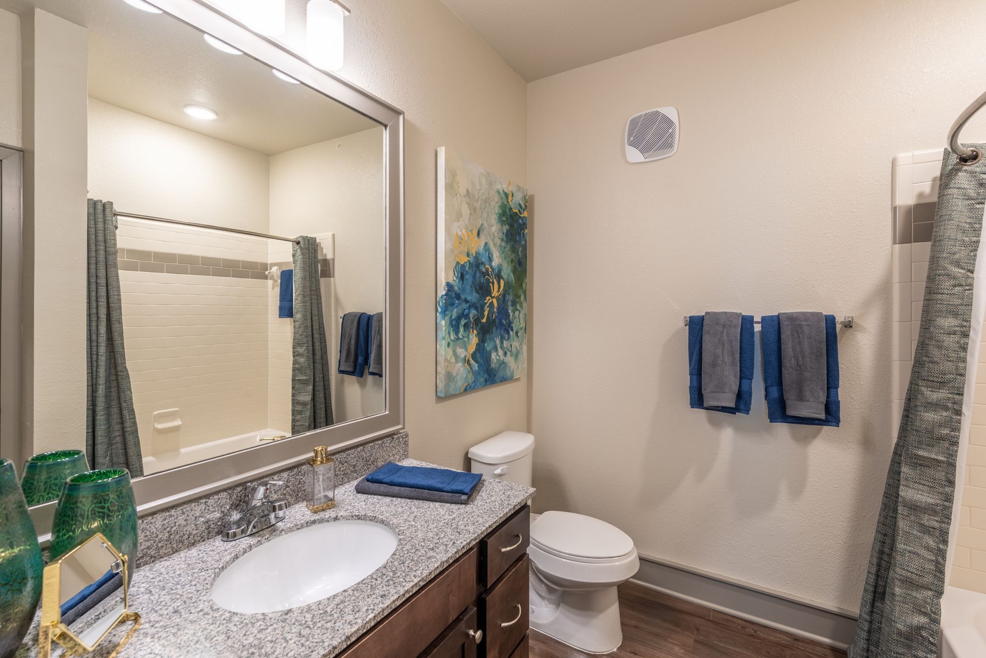 A bathroom with a sink, toilet, shower and mirror at Marquis Seven Lakes offers pet-friendly apartments for rent near Cinco Ranch, TX.