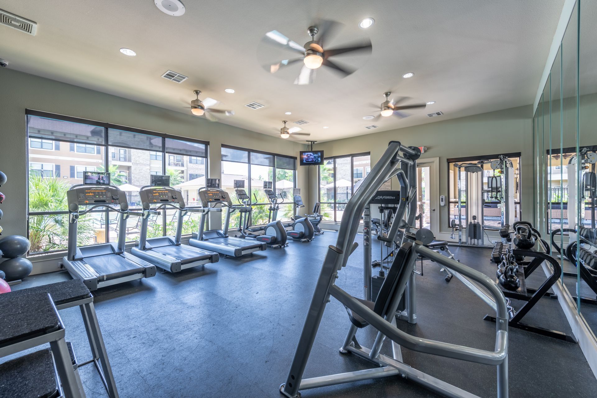 A large gym with a lot of treadmills and exercise equipment at Marquis Seven Lakes offers apartments for rent near Igloo Products Corp in Katy, TX.