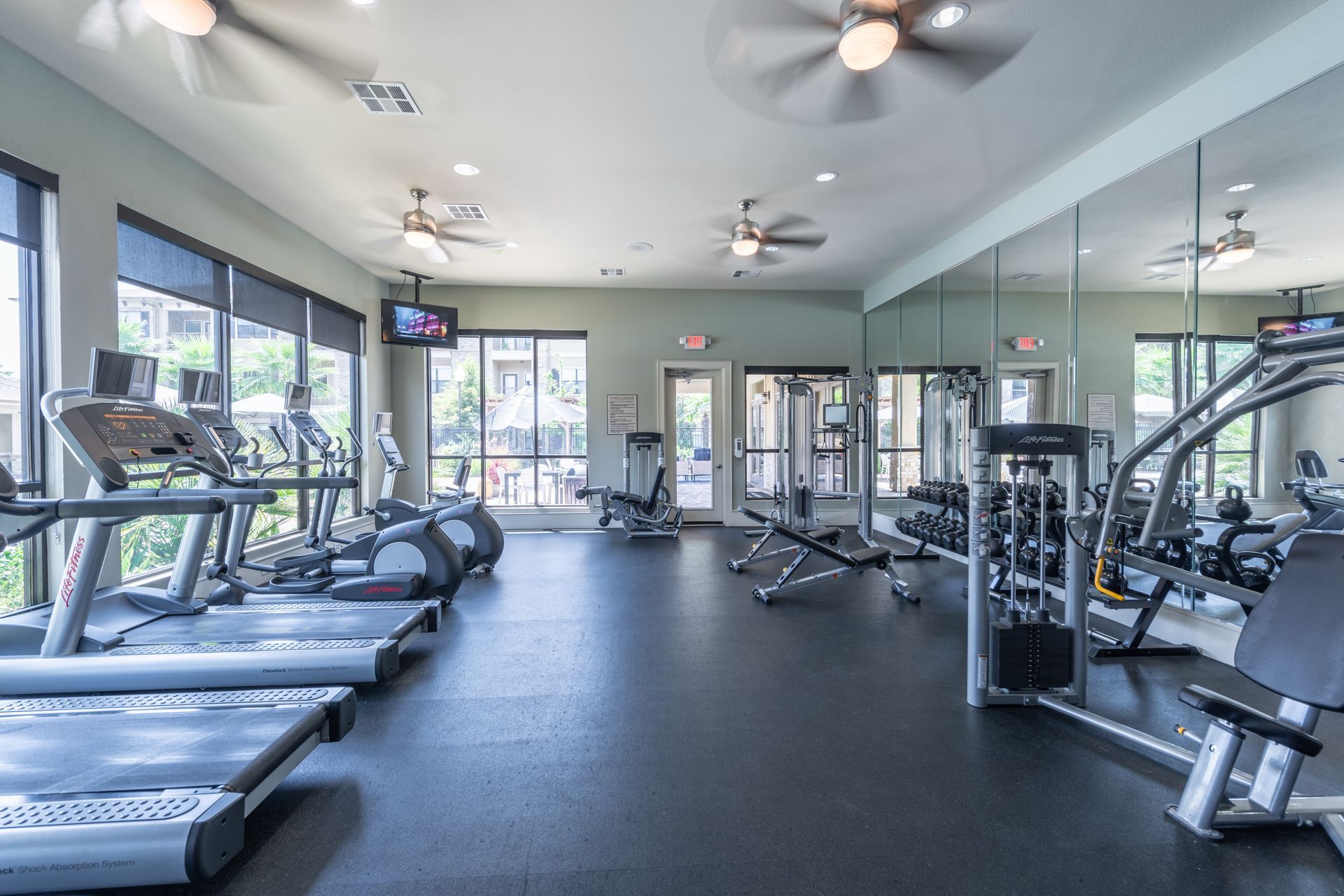 A large gym with a lot of treadmills and exercise equipment at Marquis Seven Lakes offers apartments for rent in Katy, TX.