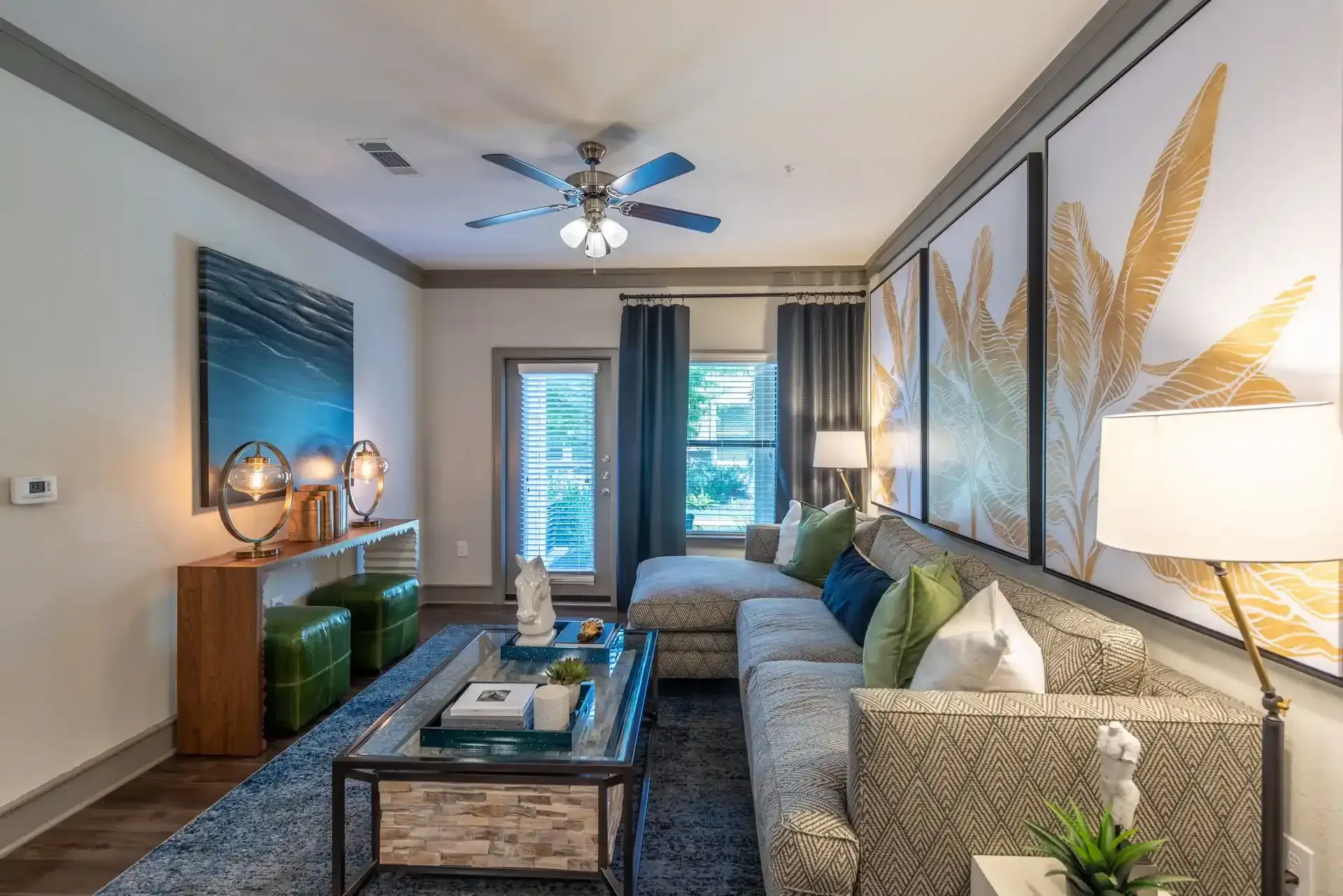 A living room with a couch, coffee table, and ceiling fan at Marquis Seven Lakes offers Cinco Ranch apartments for rent.