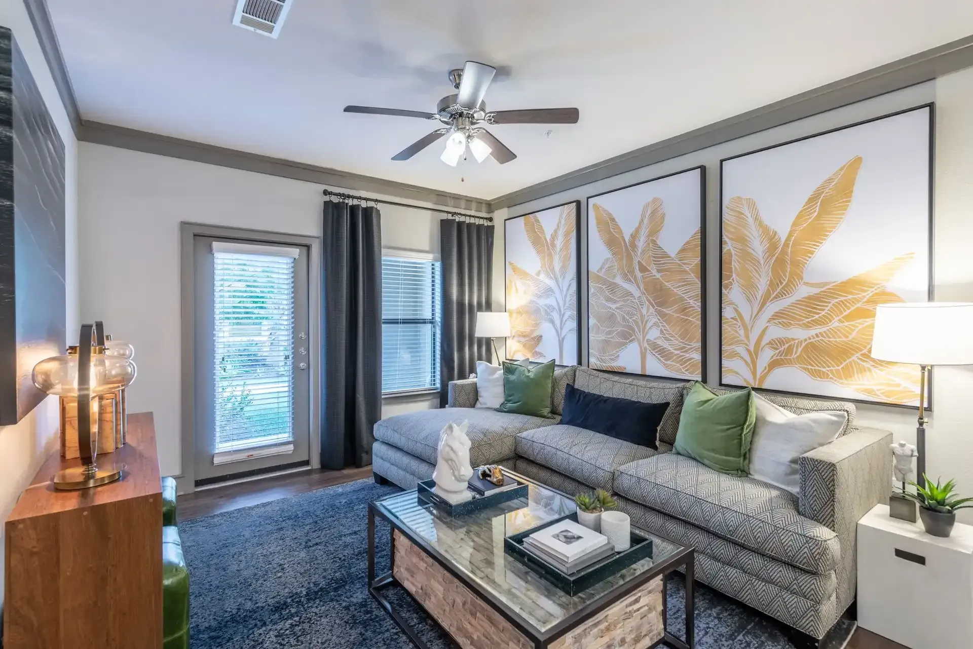 A living room with a couch, coffee table, and ceiling fan at Marquis Seven Lakes offers Cinco Ranch apartments for rent.
