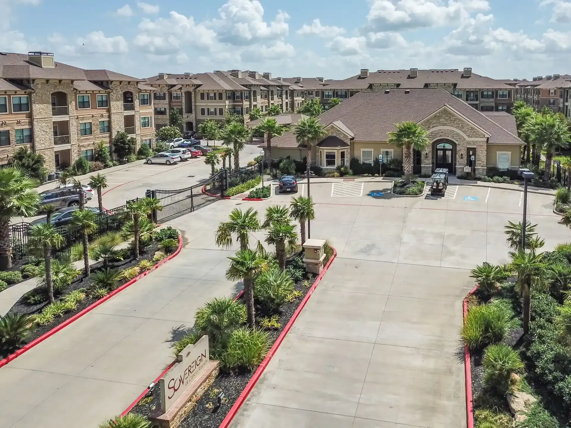 An aerial view of a large apartment building with a parking lot in front of it at Marquis Seven Lakes offers apartments in Katy, TX.