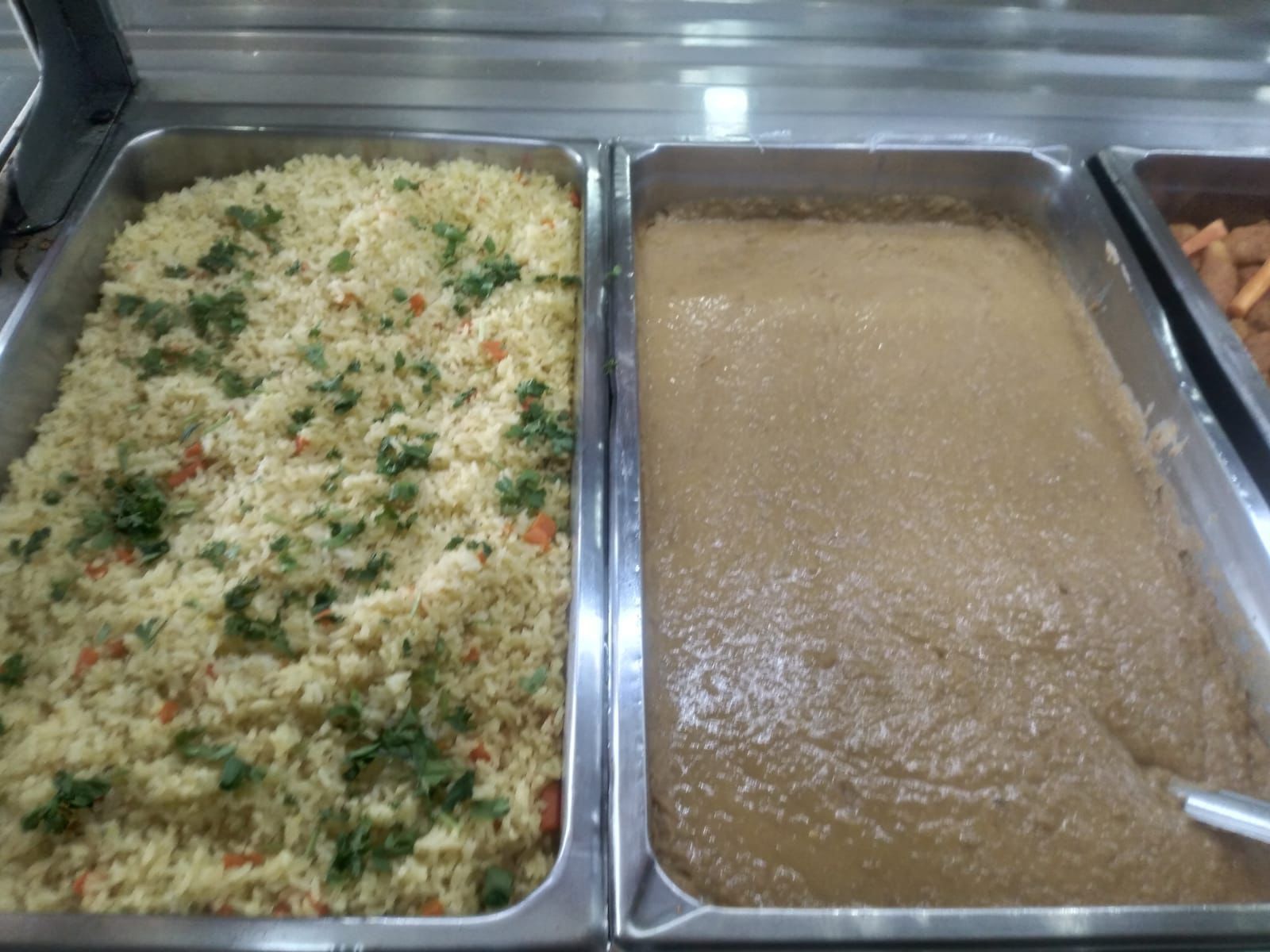Dos bandejas de comida una de las cuales es arroz y la otra es sopa.