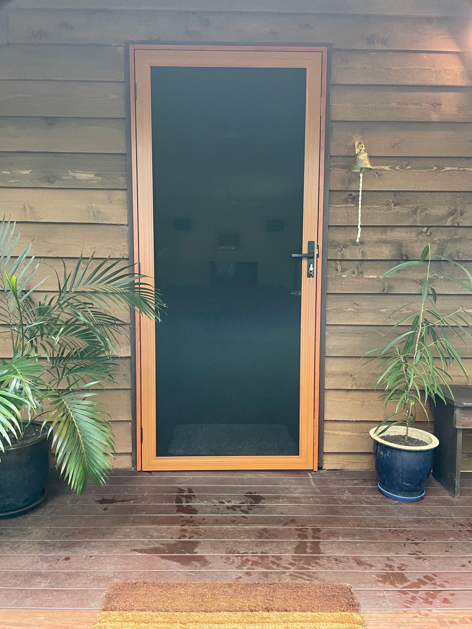 Image of a secureview stainless steel security door with western red cedar coloured frame