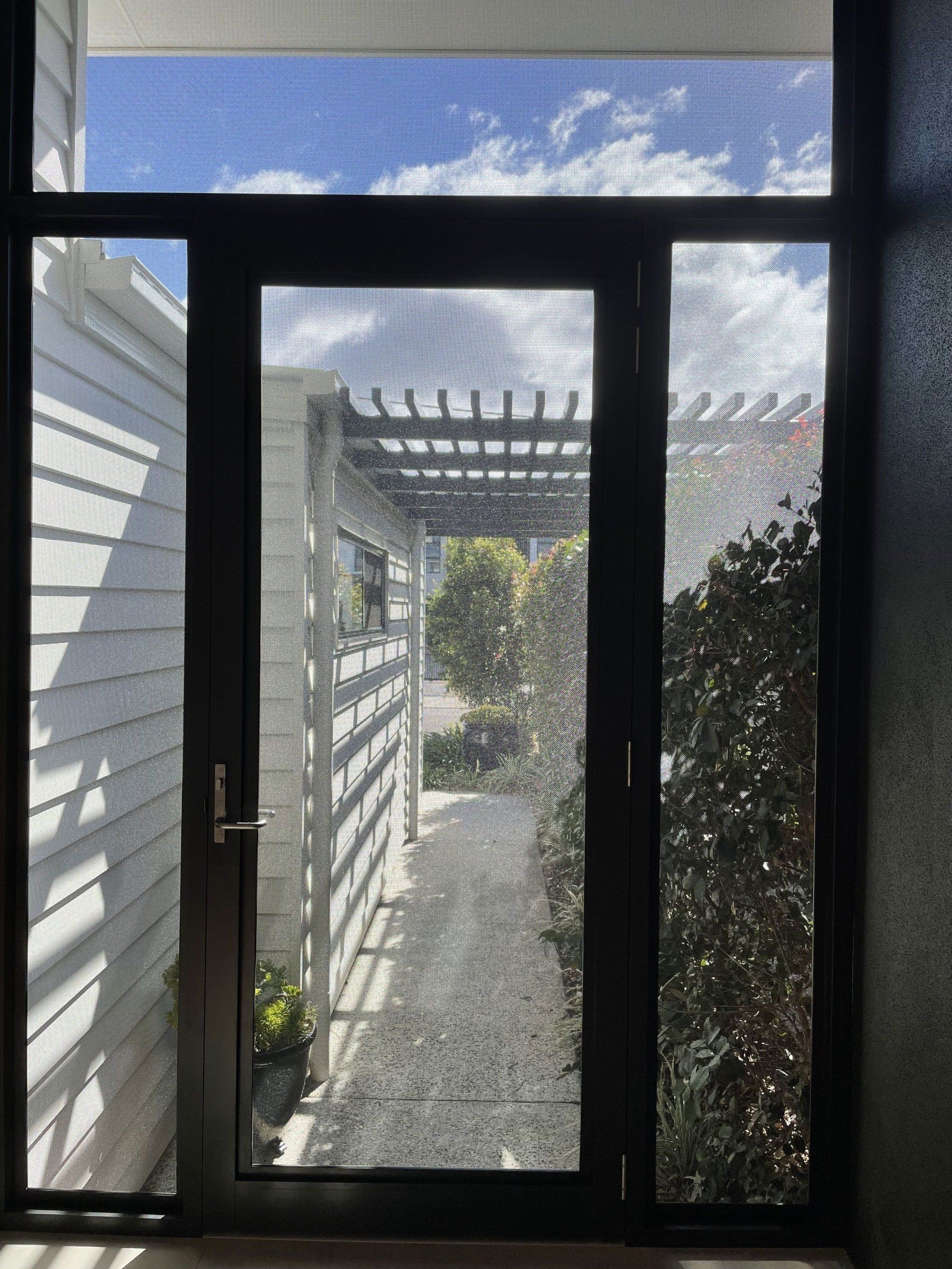 Image of the front porch of a house screened with stainless steel mesh and a stainless steel mesh security door