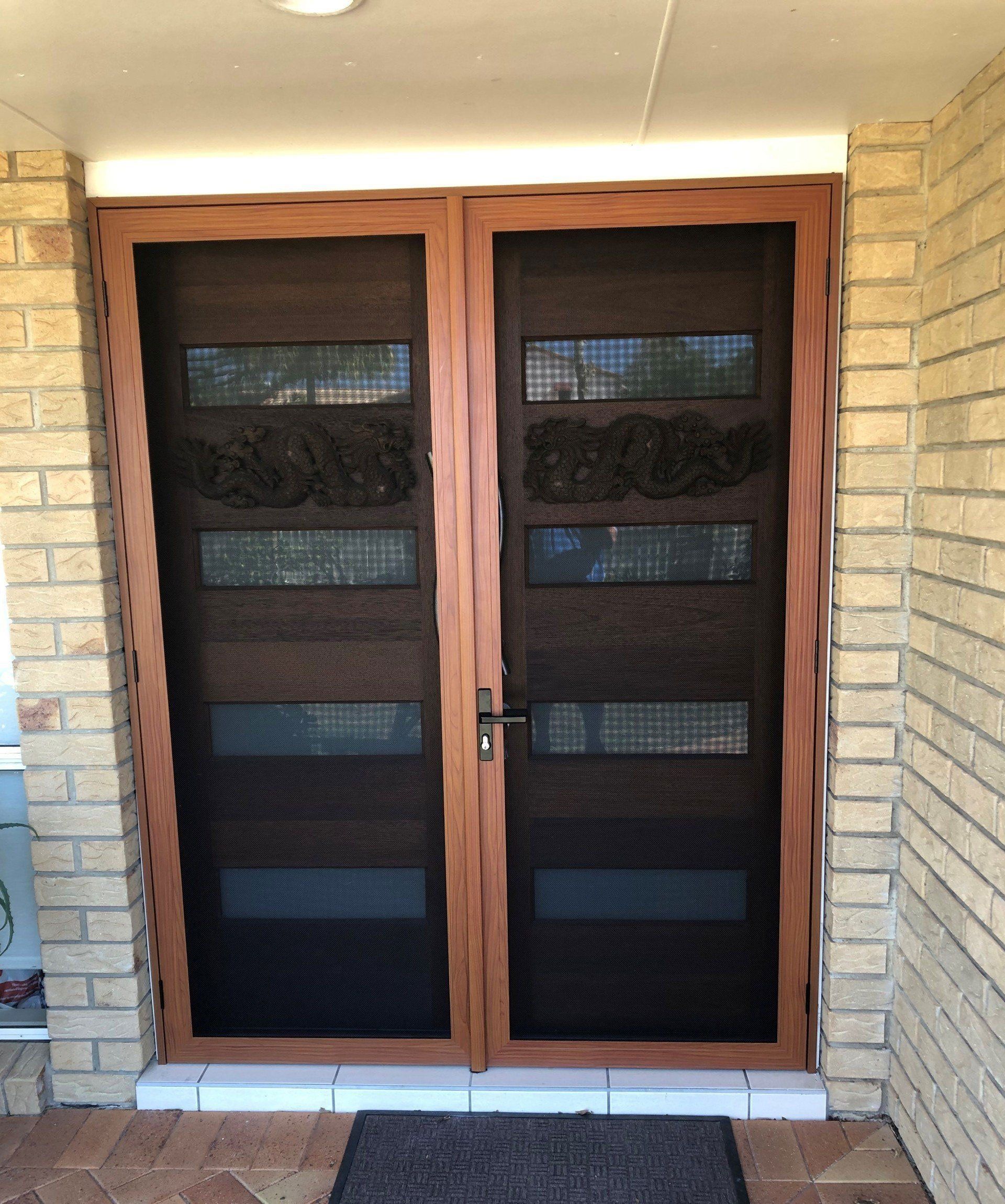 Image of double set of stainless steel security doors with western red cedar frames on the front entry of a house