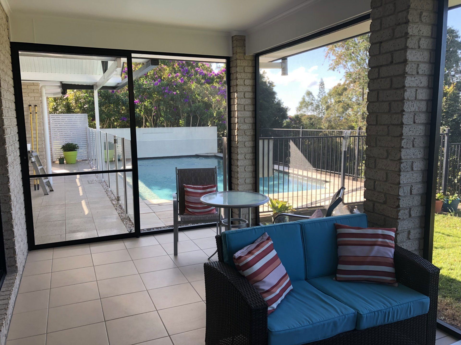 Image of a patio enclosure on a house screened with insect mesh and looking out to the swimming pool in the background