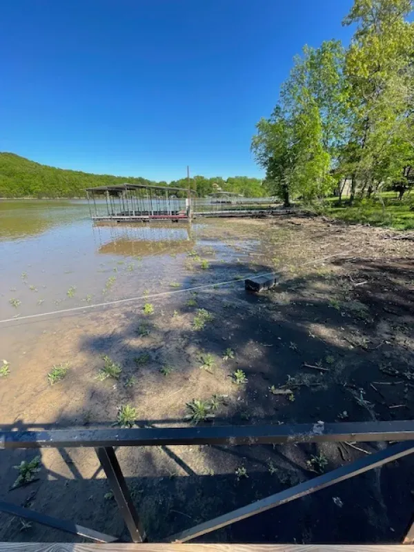 A flooded area with a dock and a boat in the water.