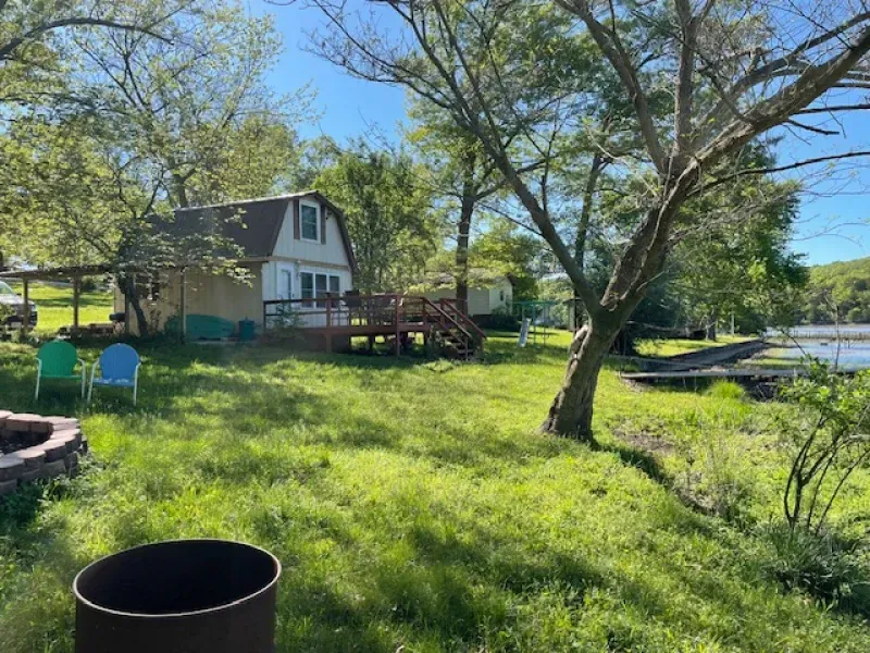 There is a fire pit in the grass in front of a house.