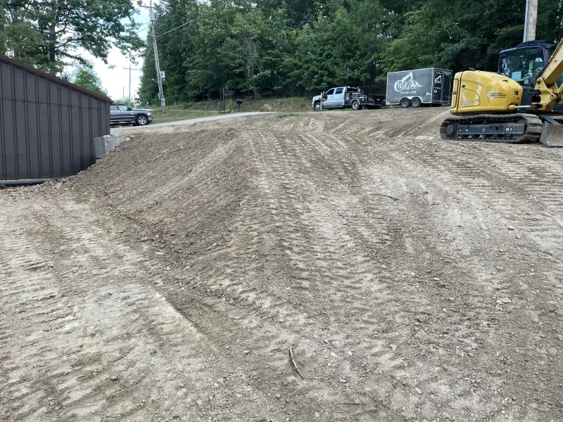 A yellow excavator is working on a dirt field.