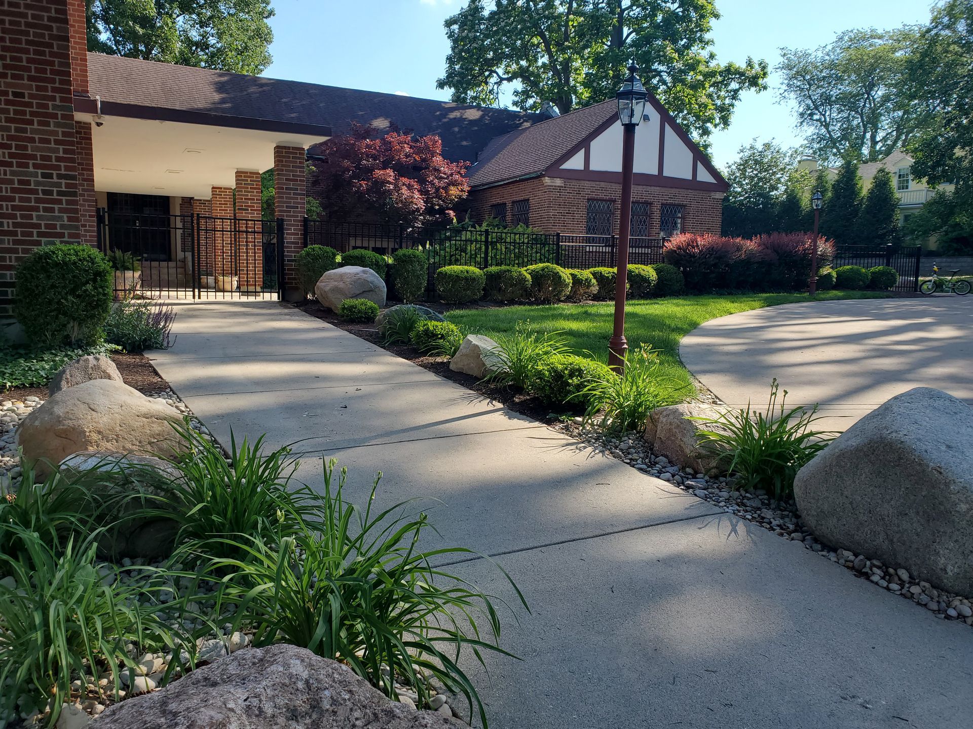 Brick building with walkway, landscaping, and large rocks.