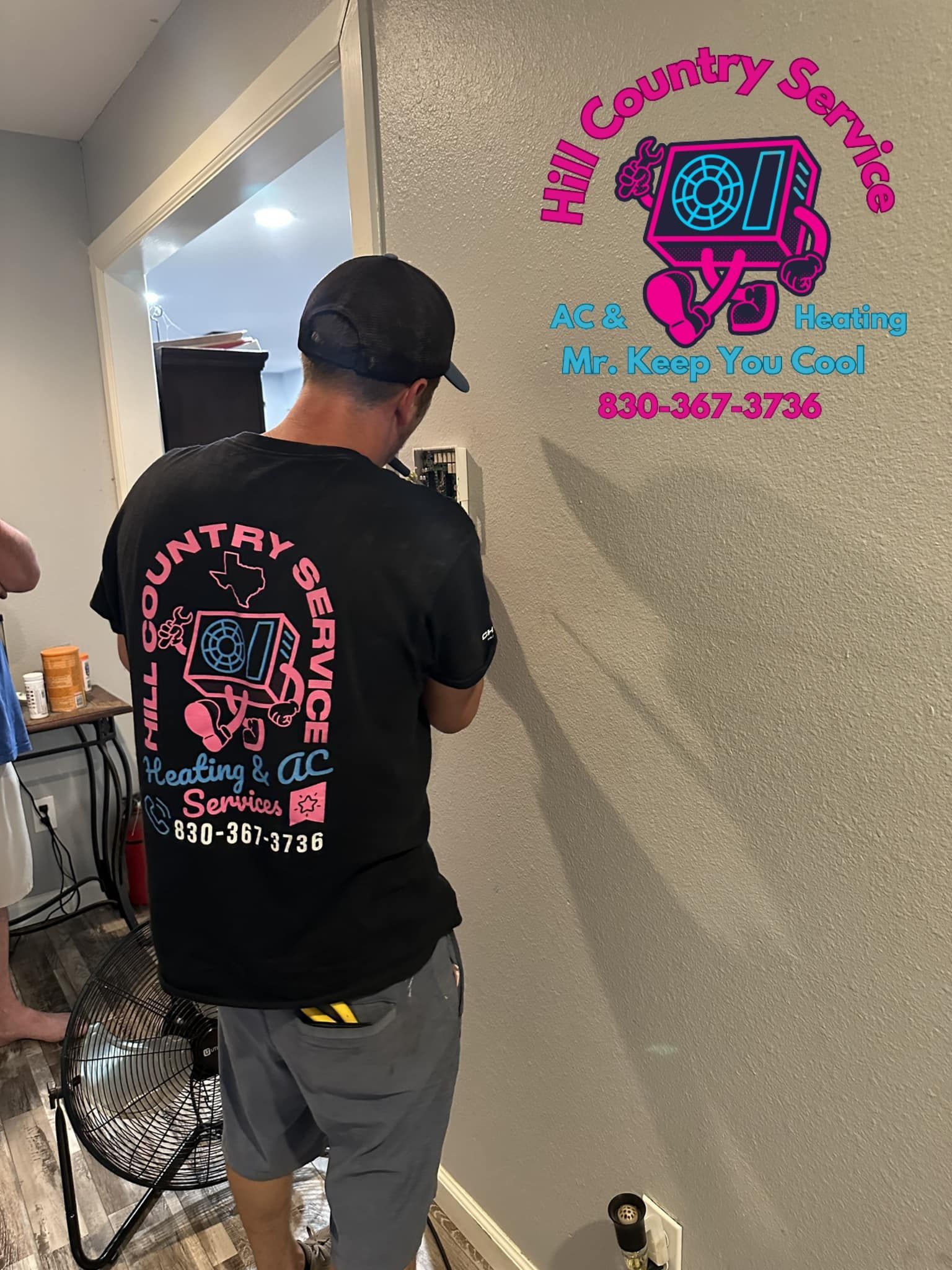 A man in a black shirt is working on a wall.