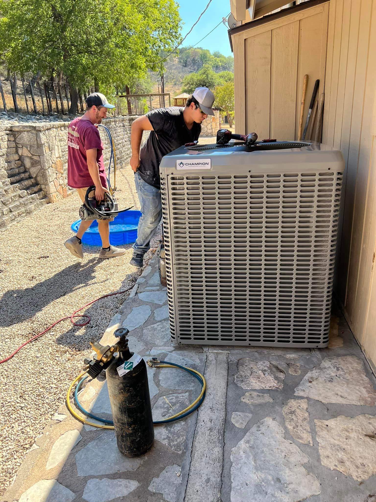A man is working on an air conditioner outside of a building.