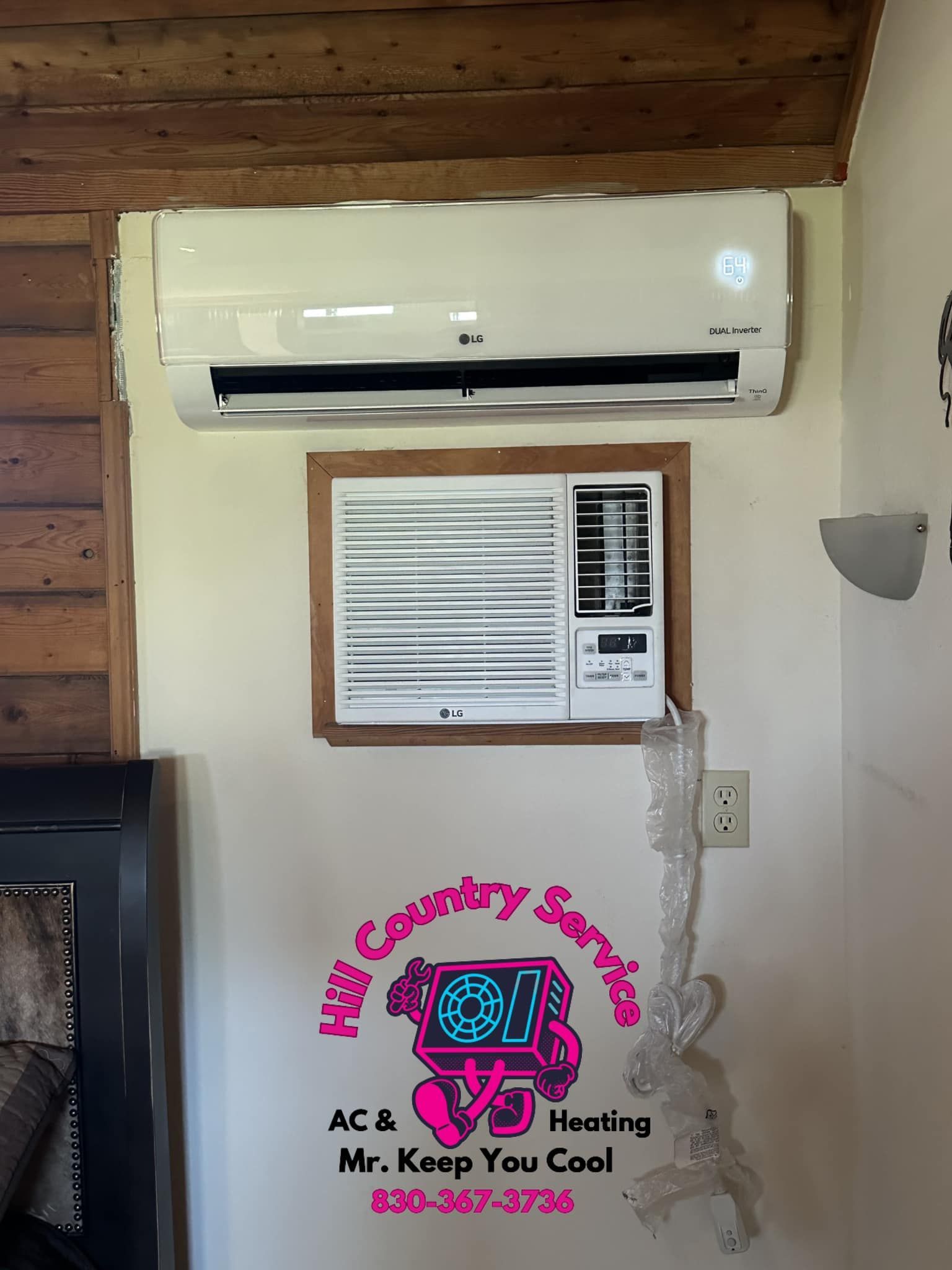 A white air conditioner is mounted on a wall next to a sign that says