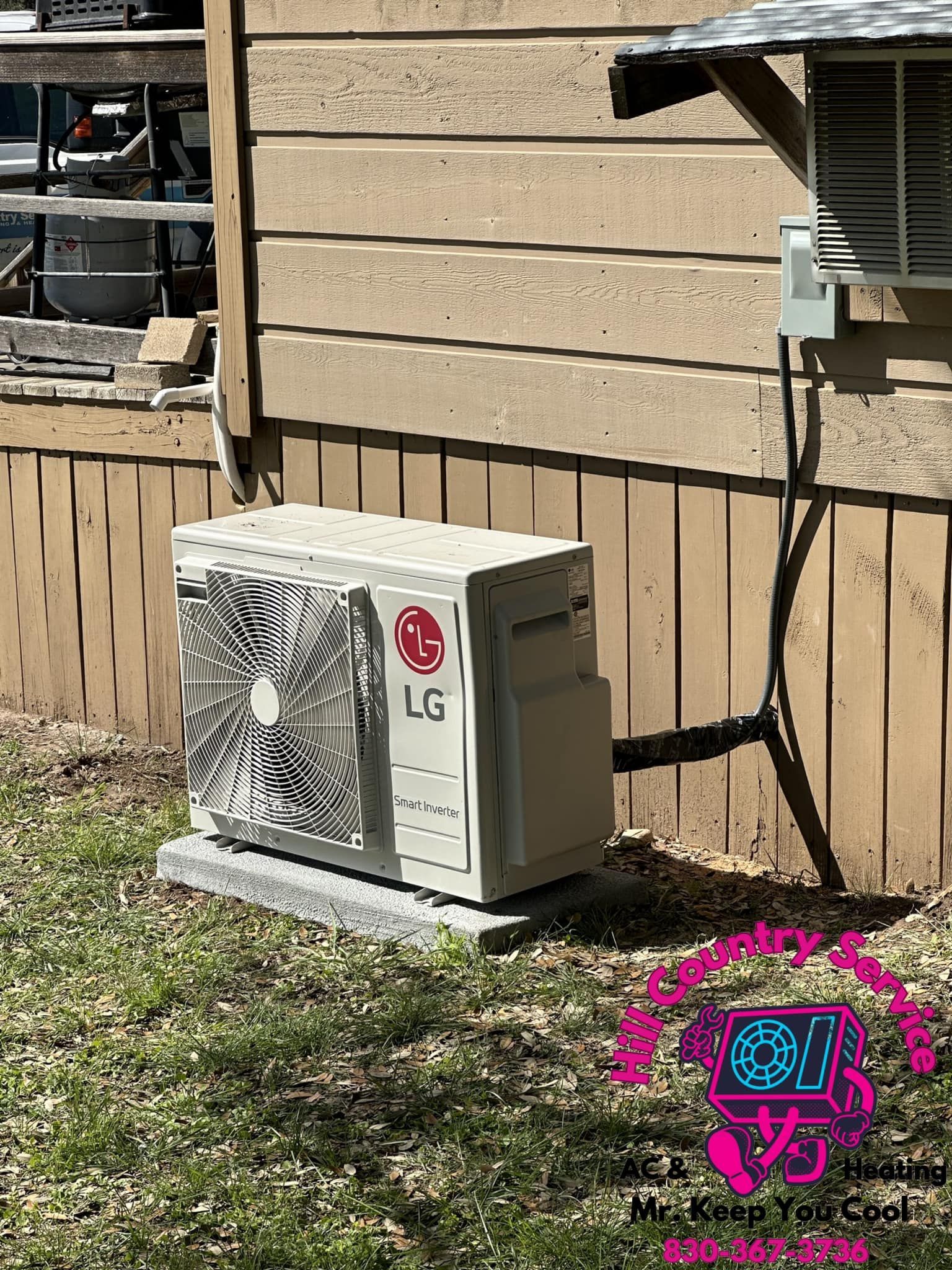 An lg air conditioner is sitting on the side of a house.