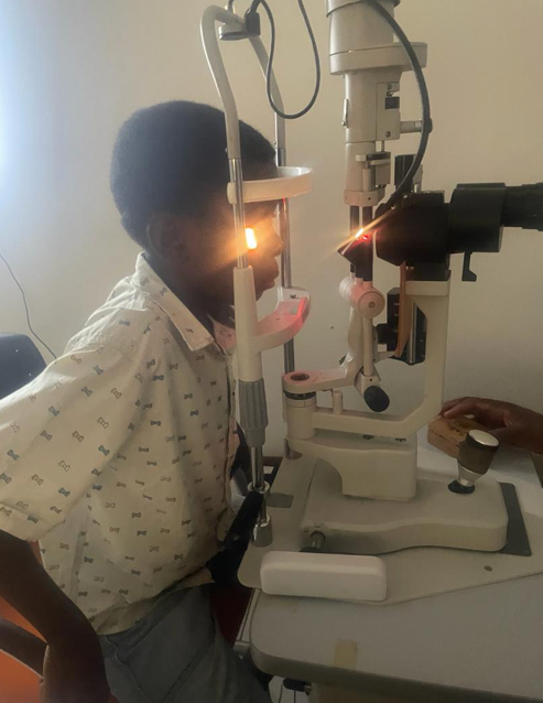 A young boy is getting his eyes examined by an ophthalmologist