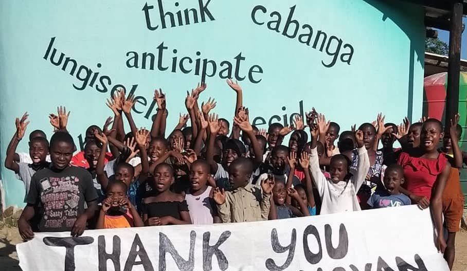 A group of children holding a thank you sign