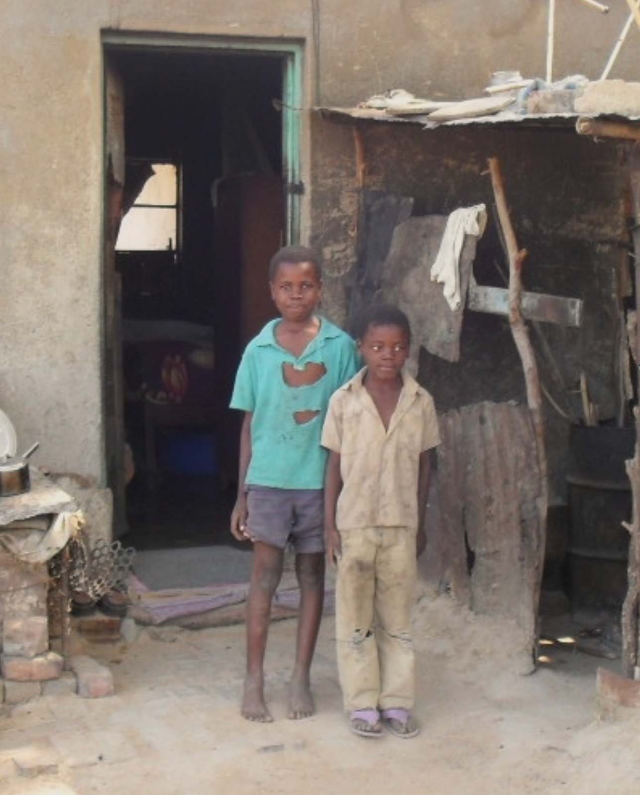 Two young boys are standing in front of a building
