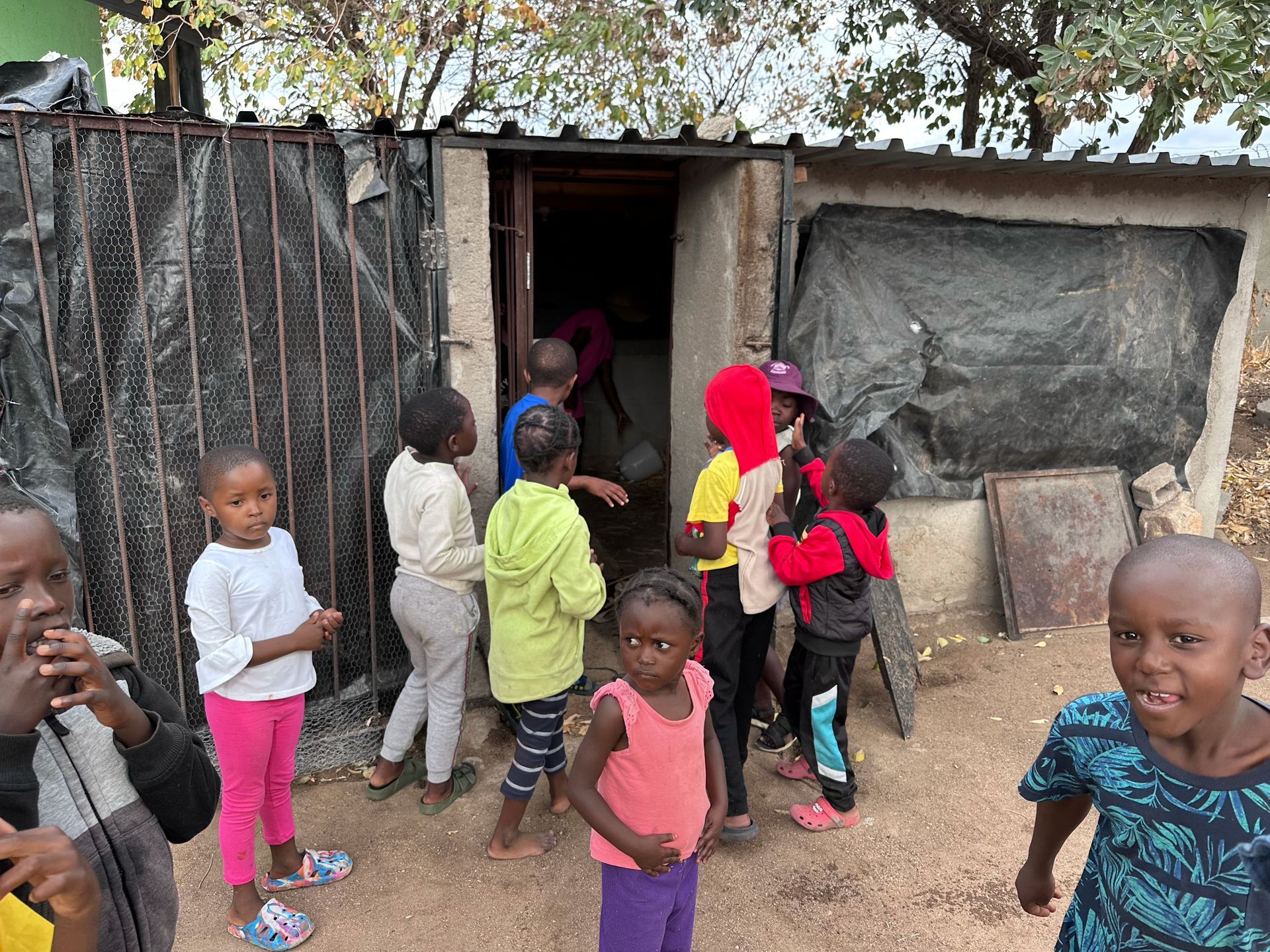 A group of children are standing outside of a building.