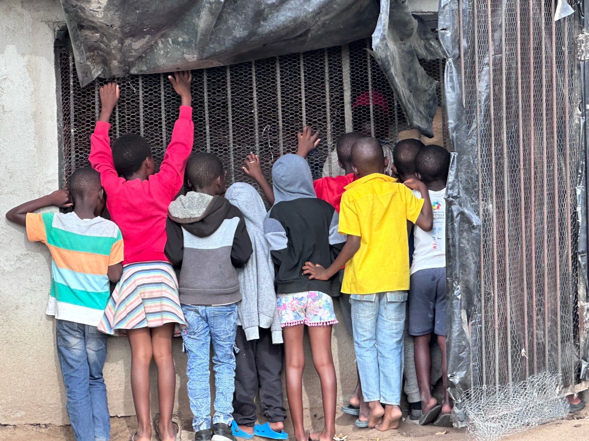 A group of children are standing in front of a building.